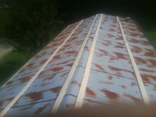 Rusted metal roof panels with new wood purlins before replacement — Storm Damage Roof Repair in Lindenhurst by Roofing Brothers