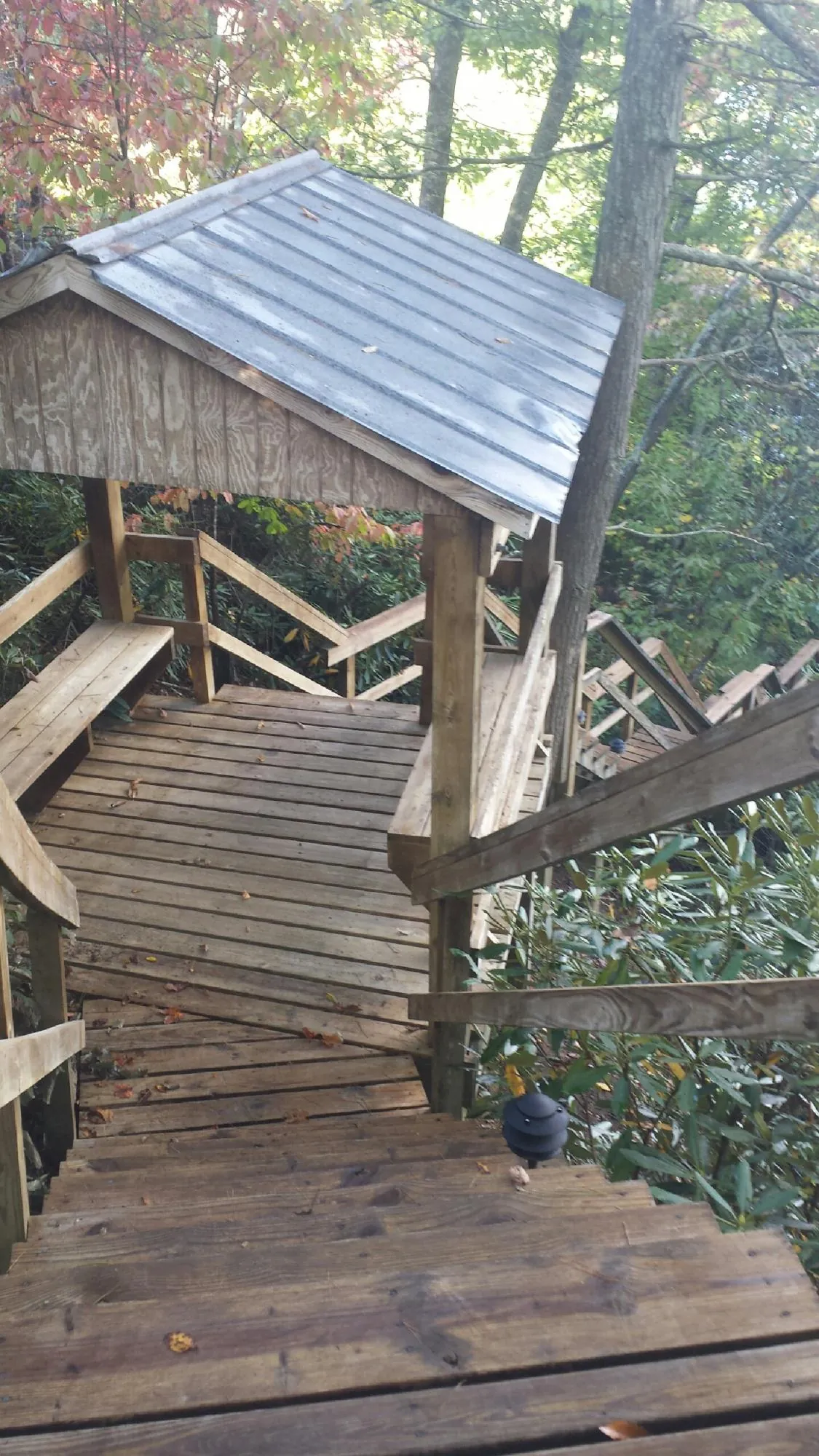 Metal roofed shelter over wooden steps on a wooded walkway — Skylight Repair & Installation work by our crew in Lindenhurst